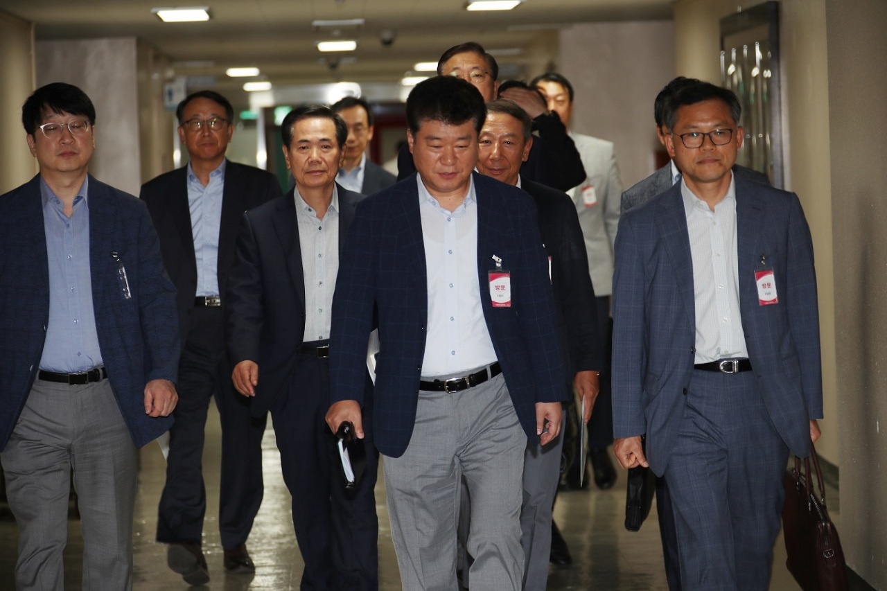 Representatives of Korean semiconductor and display industries walk to a meeting with Trade Ministry officials at the central government complex in Seoul on Monday. (Yonhap)