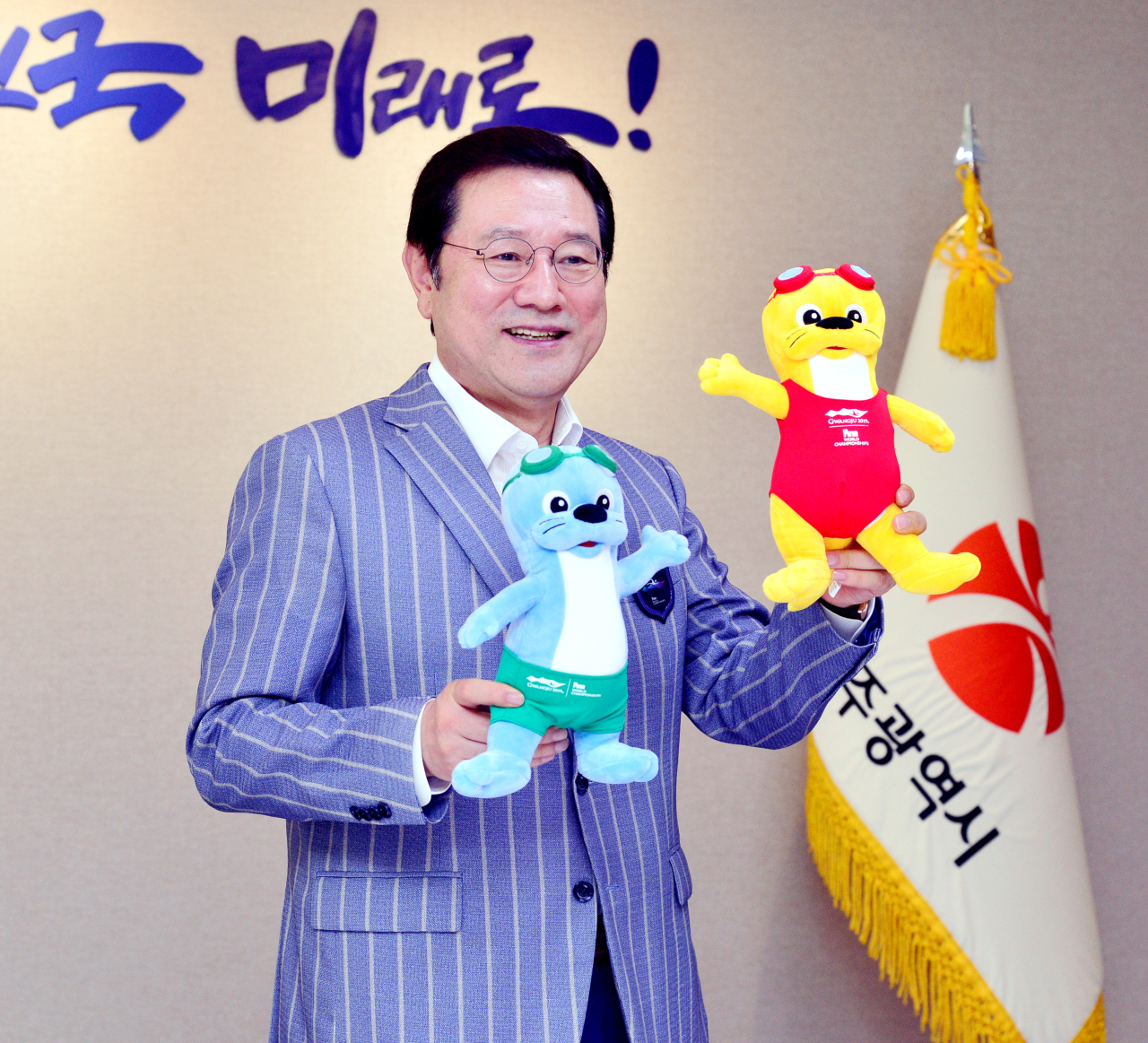 Gwangju Mayor Lee Yong-sup poses with mascots for the 18th FINA World Championships Gwangju 2019 before an interview with The Korea Herald at the Gwangju Metropolitan City Hall on Tuesday. (Park Hyun-koo/The Korea Herald)
