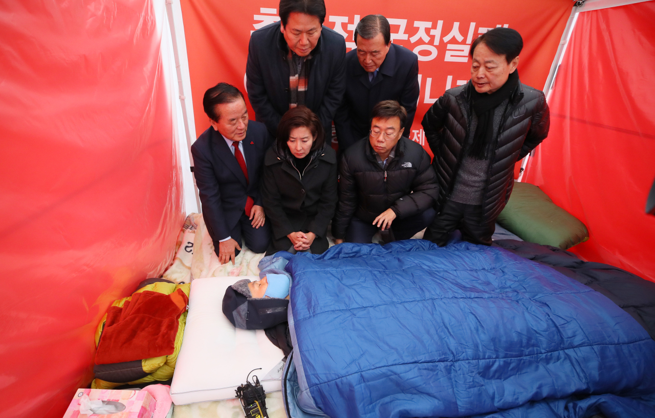 LKP lawmakers meet hunger-striking party chief Hwang Kyo-ahn in a tent on Wednesday. (Yonhap)