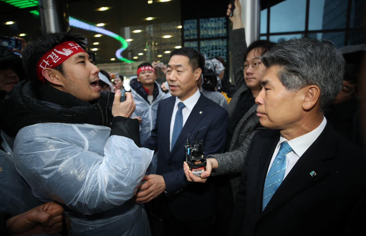 IBK CEO Yoon Jong-won is blocked by a union member outside the bank’s headquarters in central Seoul on Jan. 7. (Yonhap)