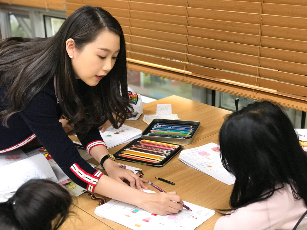 Kim Jung-ah, the writer of “The Korean Traditional Art Minhwa Coloring Book,” teaches coloring minwha with color pencils (Courtesy of Kim Jung-ah)