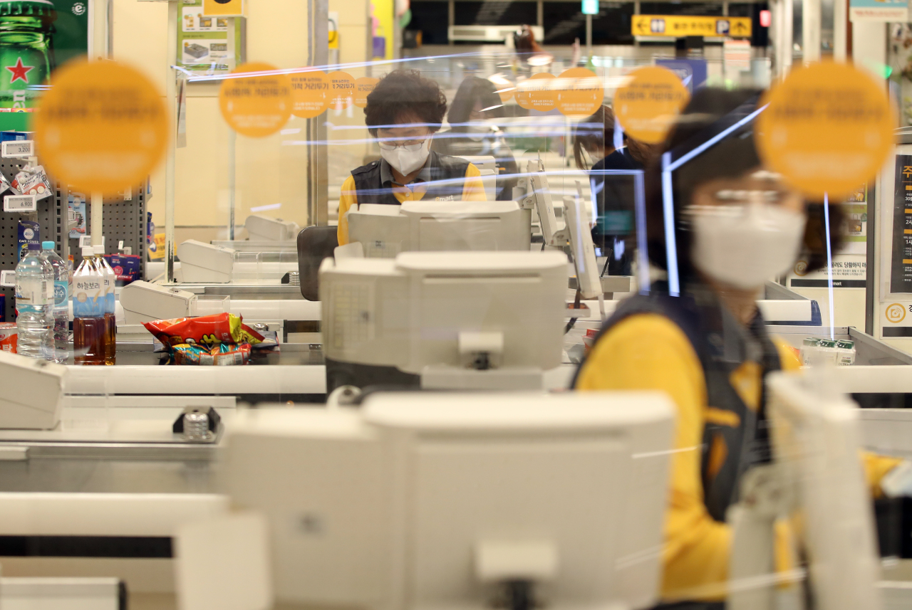 Workers wear face masks at a grocery store in Daegu. (Yonhap)