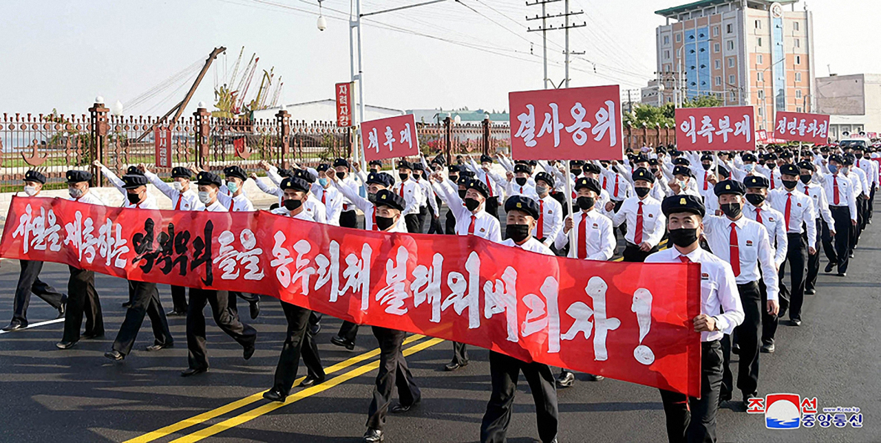 A photo released by Korean Central News Agency shows North Korean students marching in protest of anti-North Korean leaflets. (KCNA-Yonhap)