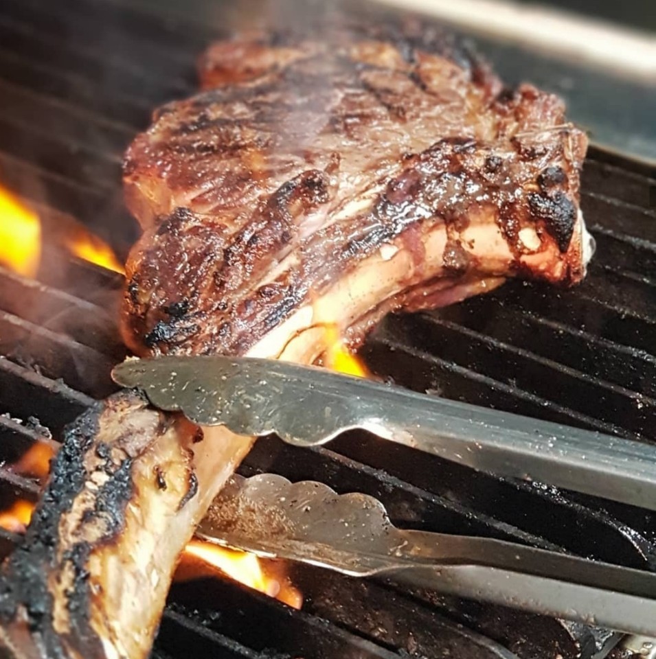 The Porterhouse Butcher and More’s tomahawk steak, essentially a bone-in ribeye steak, is dry-aged for six to 10 weeks (The Porterhouse Butcher and More)