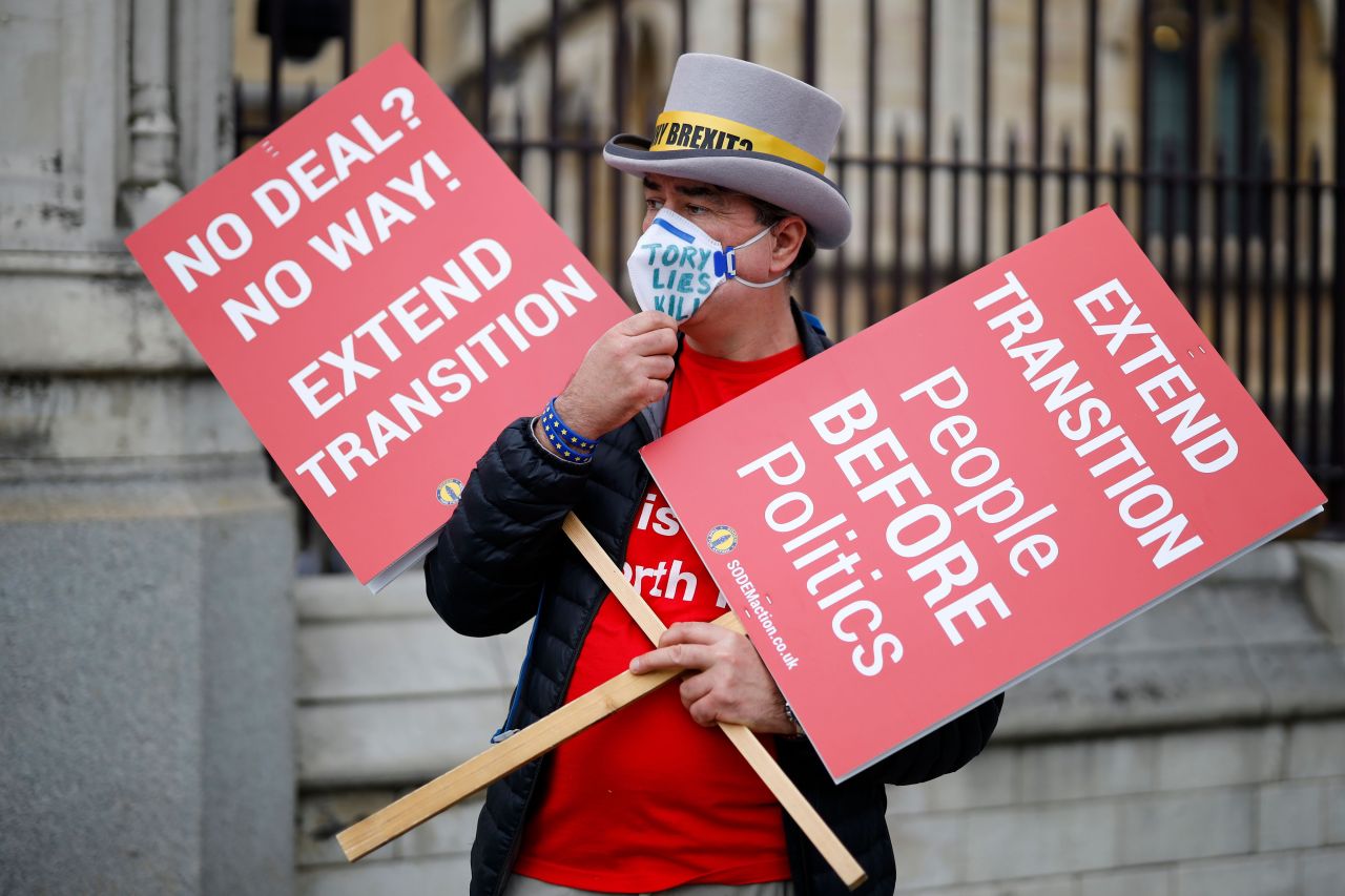 A demonstrator holds placards demanding extension of Brexit transition period outside the Houses of Parliament in London, Britain, on Wednesday. (AFP-Yonhap)