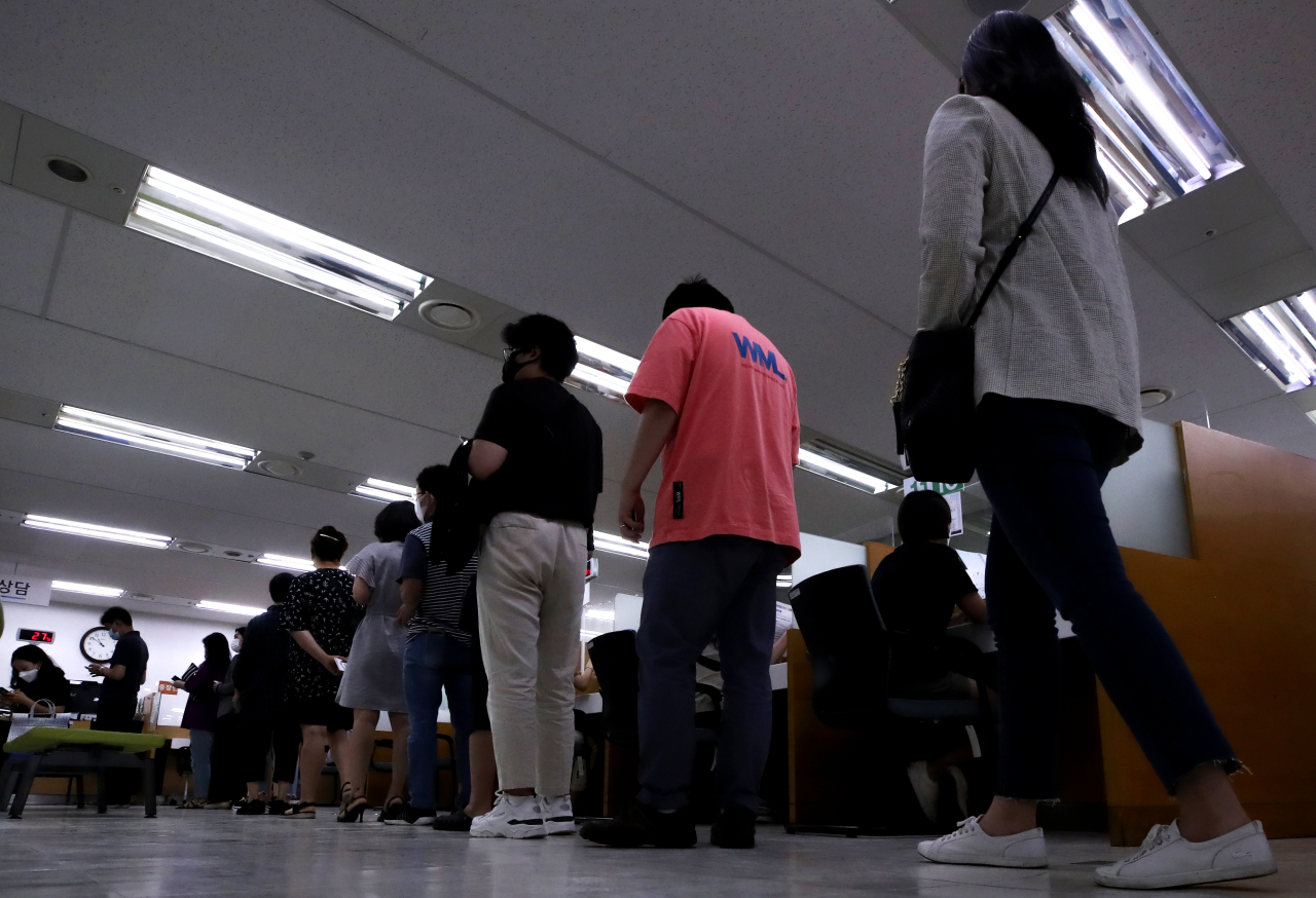 Visitors to a regional office of the Ministry of Employment and Labor in Seoul wait in line to apply for unemployment benefits earlier this year. (Yonhap)