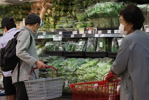 This file photo, taken Oct. 6, 2020, shows people looking at vegetables while grocery shopping at a discount store in Seoul. (Yonhap)
