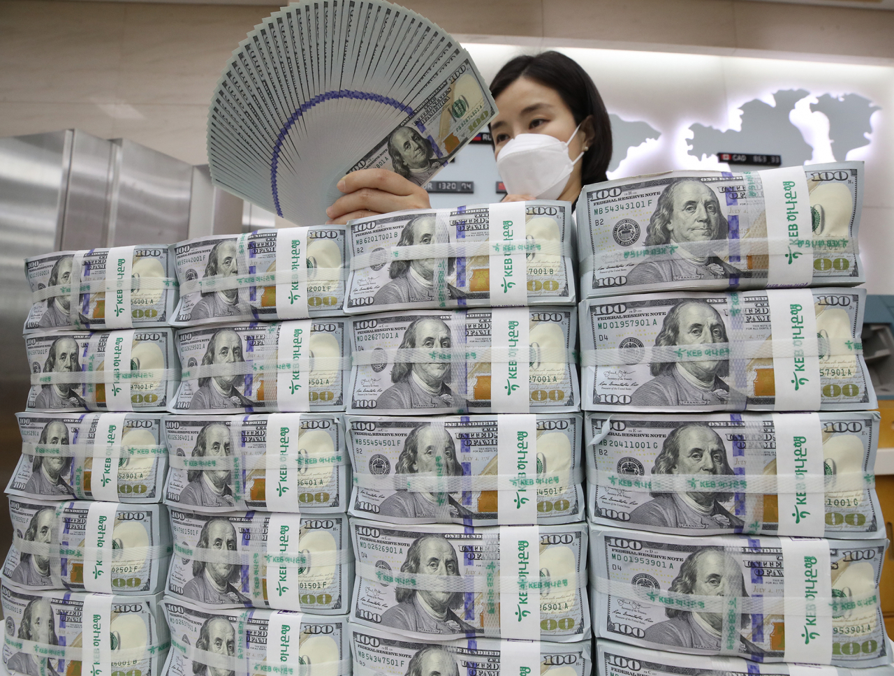 Hana Bank official in Seoul inspecting US banknotes before the release into the local financial market. (Yonhap)