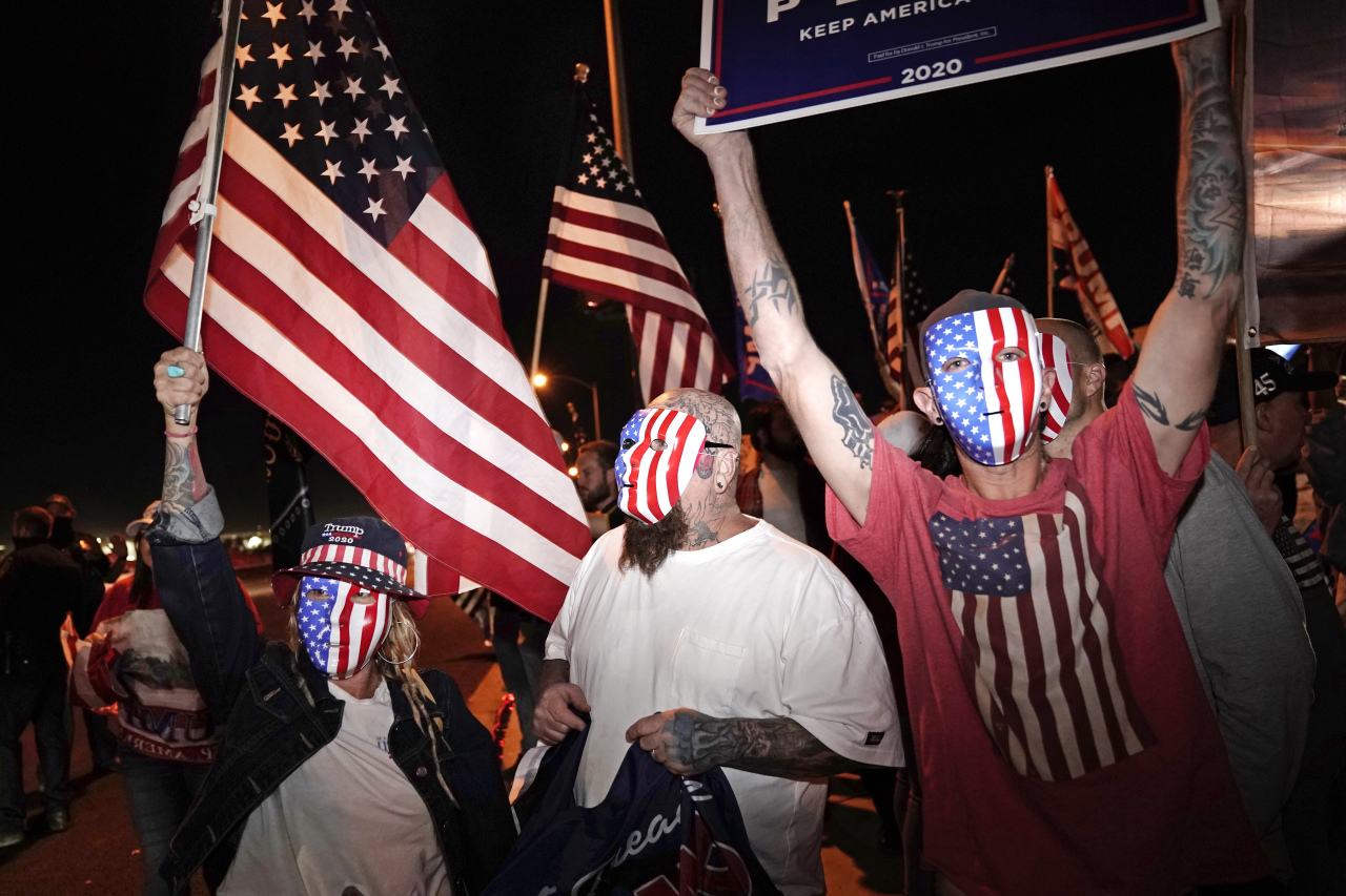 People wave flags in front of the Clark County Election Department, Thursday, in Las Vegas. (AP-Yonhap)