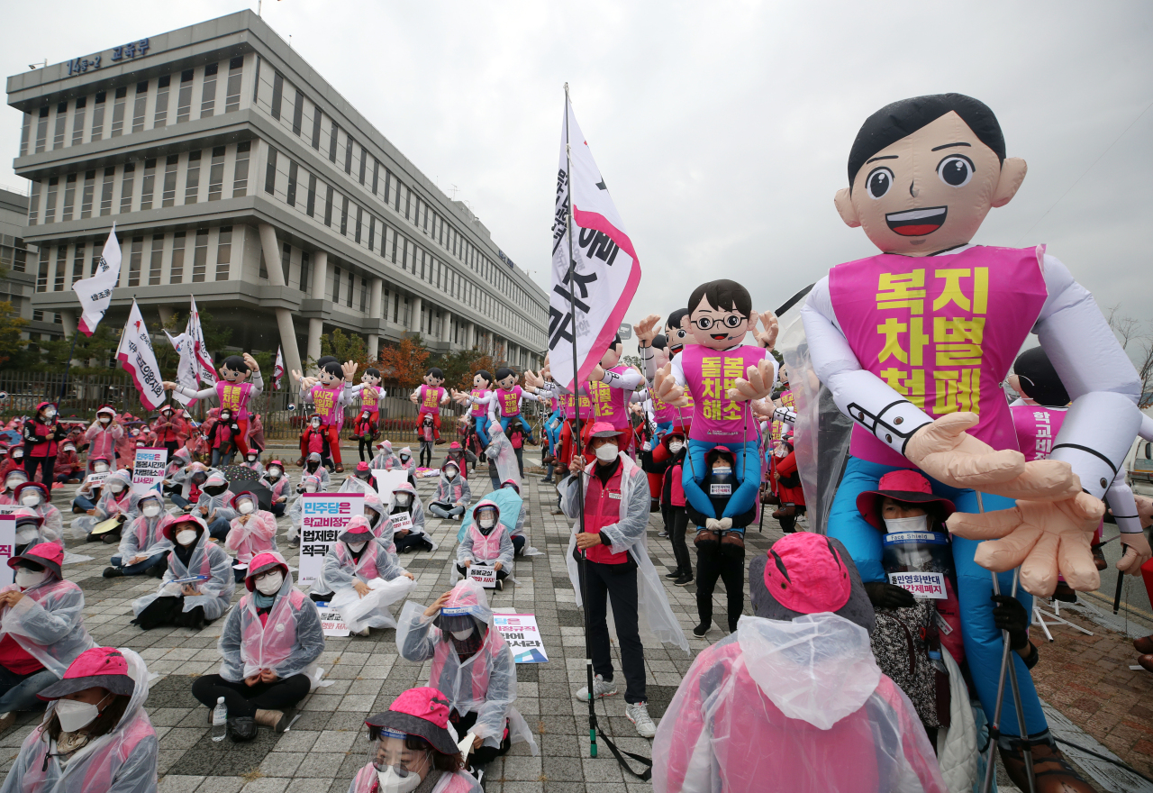 After-school care attendants stage a rally Friday in front of the Ministry of Education building in Sejong as they stage a one-day strike in protest of the ministry`s legislative revision plans. (Yonhap)