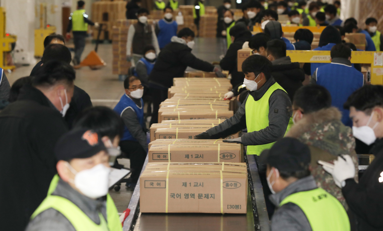 Officials prepare boxes containing test papers at a printing factory in Sejong on Monday to be delivered to local test administration authorities for Thursday‘s national college entrance exam. (Yonhap)