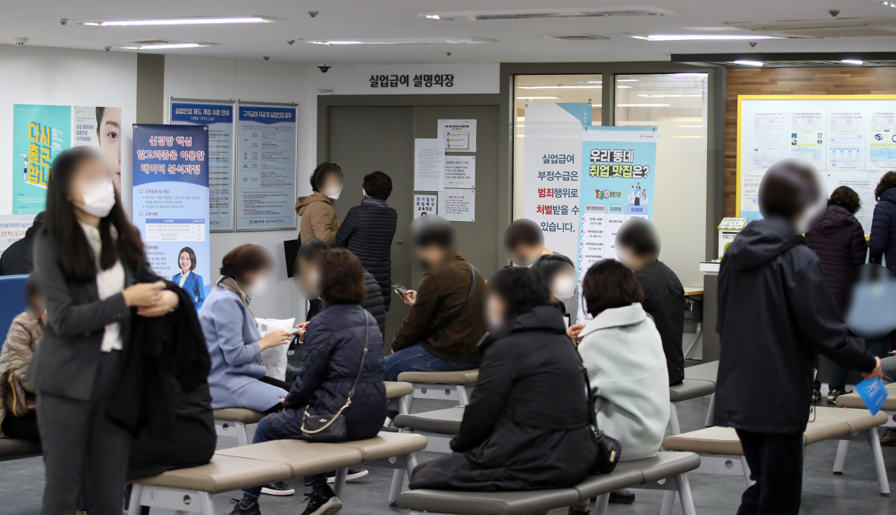 A group of people are on standby in front of a briefing room for unemployment benefits at a regional office of the Employment and Welfare Plus Center in Seoul earlier this year. (Yonhap)