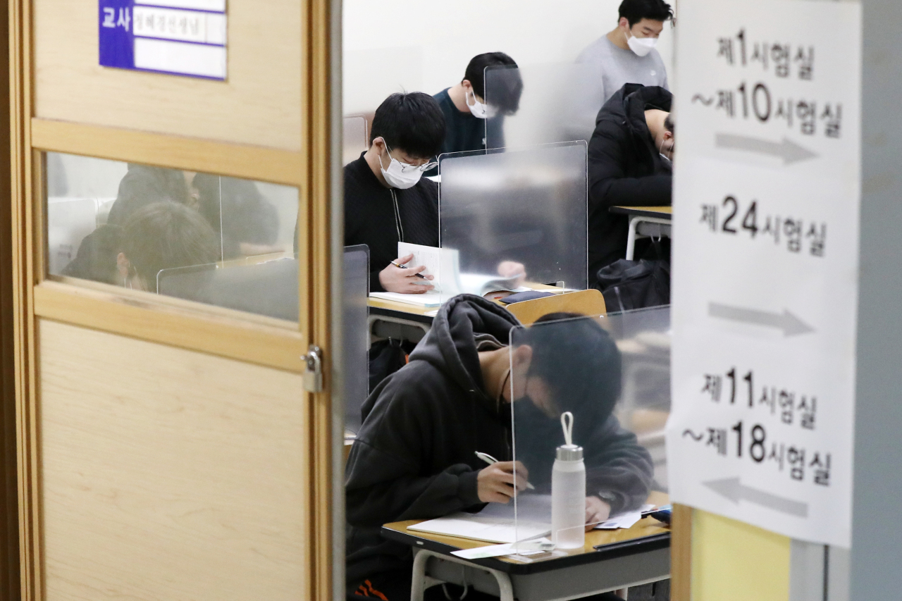 Students at a testing center in Jongno-gu, central Seoul, review study materials Thursday morning just minutes prior to taking this year's College Scholastic Aptitude Test. (Joint Press Corp.)