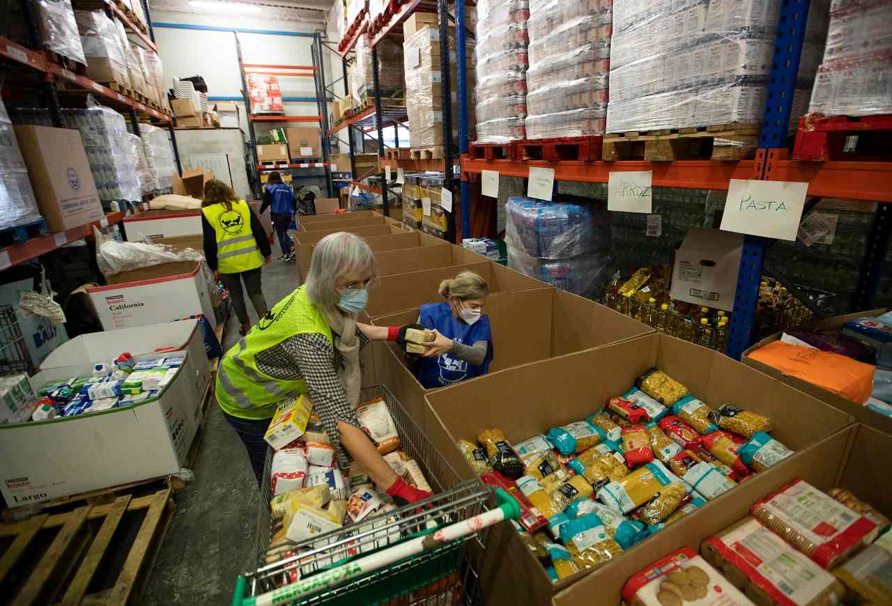 Volunteers prepare food packages to distribute to charitable organizations at the food bank in Palma de Mallorca on Wednesday. (AFP-Yonhap)