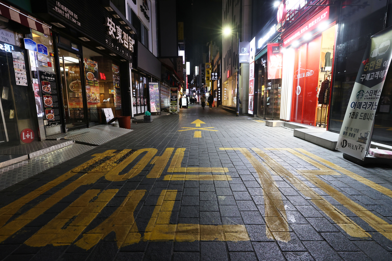 Shop lights are out at Myoung-dong, a usually busy tourist district in central Seoul, on Saturday evening. (Yonhap)