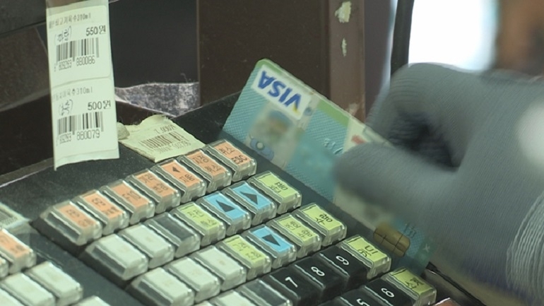 A consumer paying bills with a credit card. (Yonhap News TV)