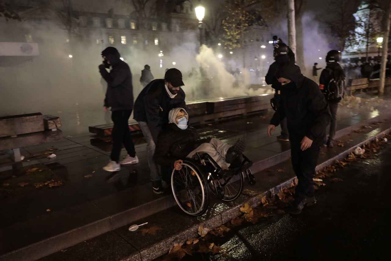 Demonstrators leave the Place de la Republique among tear gas after a demonstration, Saturday, in Paris. (AP-Yonhap)