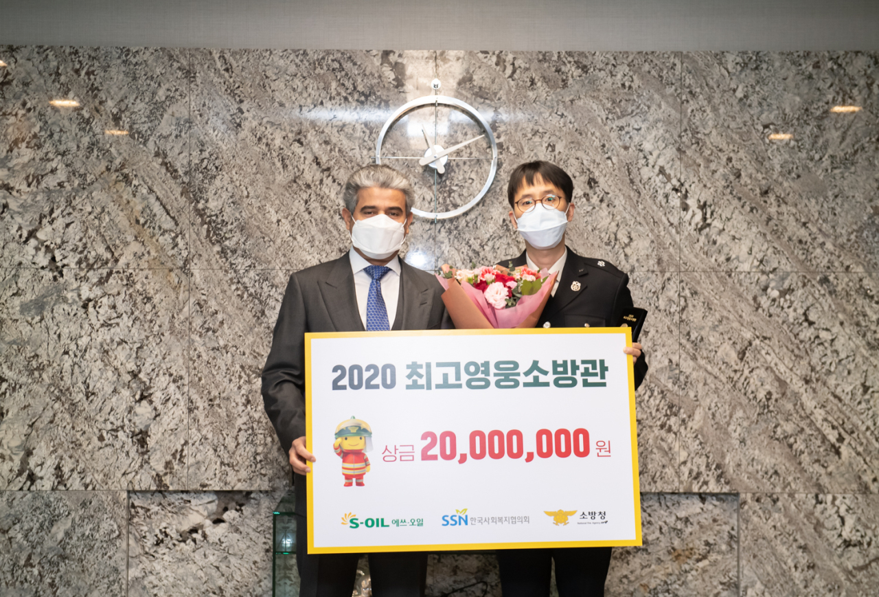 S-Oil CEO Hussain A. Al-Qahtani (S-Oil) delivers 20 million won ($18,472) to Lee Sung-ha from Incheon Central Fire Station for his dedicated service at the annual Hero Firefighters Award Ceremony held at the company‘s headquarters in Mapo-gu, western Seoul, Wednesday. (S-Oil)
