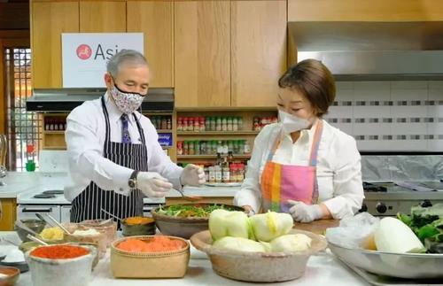 US Ambassador to South Korea Harry Harris (L) learns how to make kimchi with Chef Lee Hye-jung at the Habib House, his official residence in Seoul, on Tuesday. (Captured from the Facebook account of the Asia Korea Society Center)