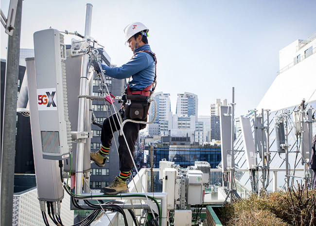 An engineer of SK Telecom works on the installation of a 5G antenna unit on the rooftop of a building in Myeong-dong, central Seoul.(SKT)