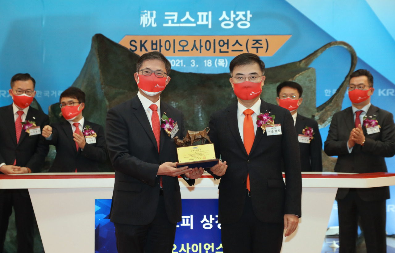 Korea Exchange Chairman Sohn Byung-doo (front right) and SK Bioscience CEO Ahn Jae-yong (front left) pose at the vaccine maker’s listing ceremony held at the KRX Seoul office Thursday. (The Korea Exchange)