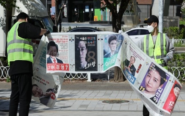 Officials remove election posters after the April 7 by-elections in Seoul. The above picture is not directly related to the article. (Yonhap)