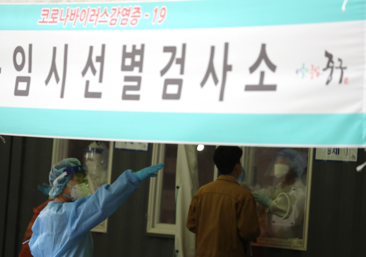 A medical worker conducts a coronavirus test at a makeshift clinic in front of Seoul Station on Thursday. (Yonhap)