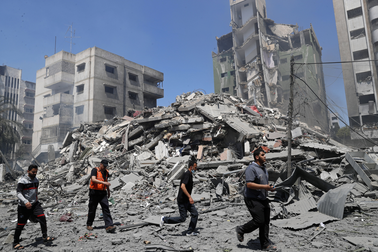 People inspect the the rubble of the Yazegi residential building that was destroyed by an Israeli airstrike, in Gaza City, Sunday. (AP)