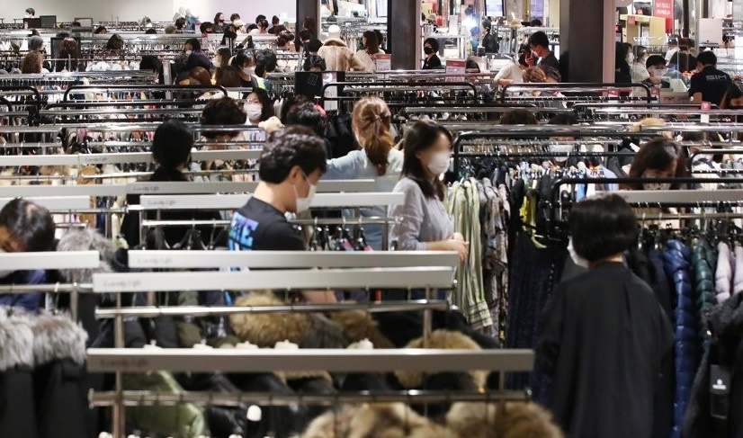 Shoppers look at racks of clothes at a department store in Seoul. (Yonhap)