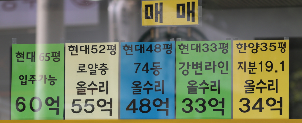 Advertisements on the window of a real estate agency in Apgujeong-dong, Seoul, indicate that asking prices of some apartment units in the district hover around 100 million won ($90,000) per 3.3 square meters. (Yonhap)