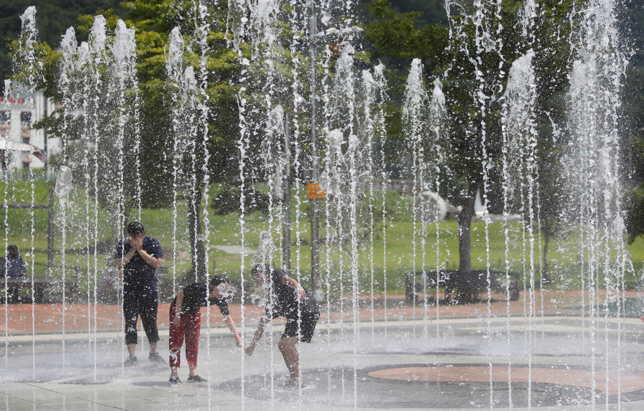 Citizens play in the water shooting from a fountain at the Chilgok-bo Ecological Park in North Gyeongsang Province in a photo taken last week. (Yonhap)