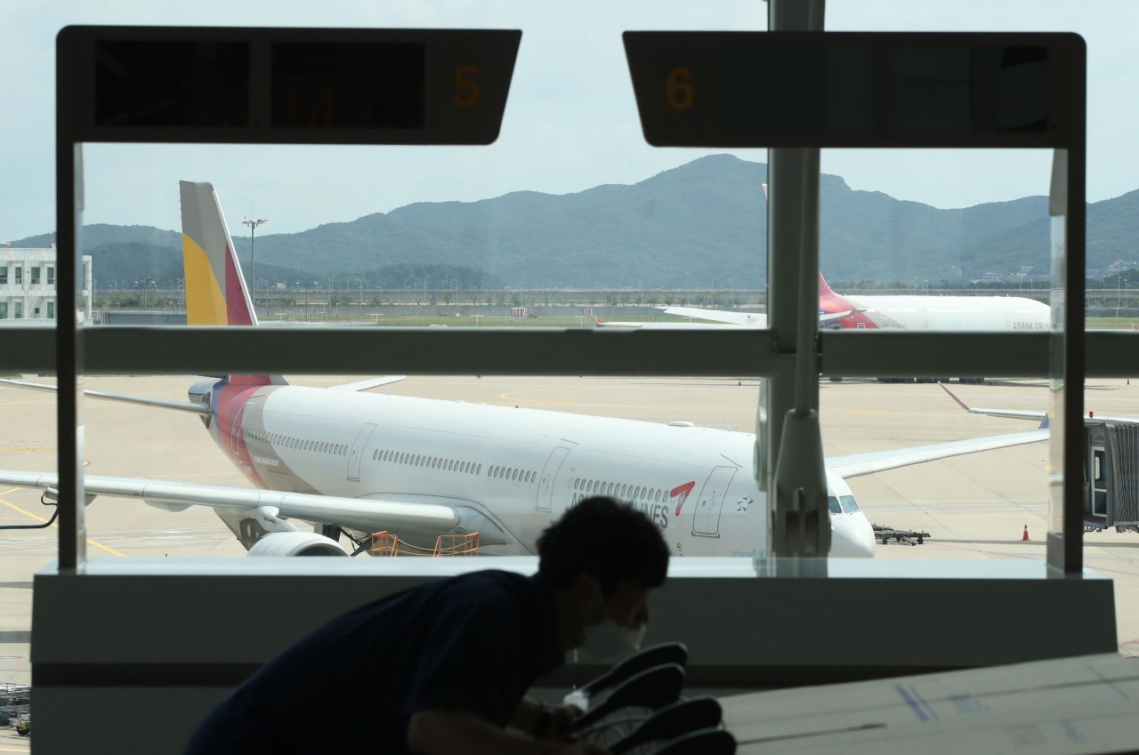 An Asiana Airlines plane is seen through the window at Incheon Airport‘s Terminal 1. (Yonhap)