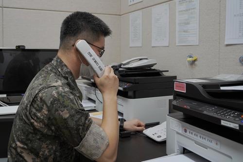 This photo, provided by the defense ministry on Tuesday, shows a South Korean service member using the inter-Korean western military communication line. (defense ministry)