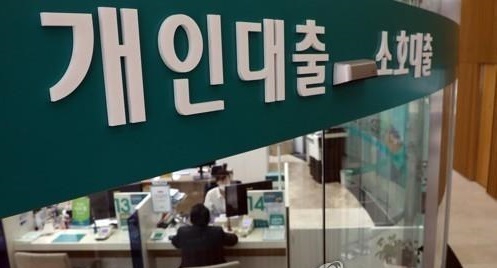 A bank official explaining a loan product to a visiting customer. (Yonhap)