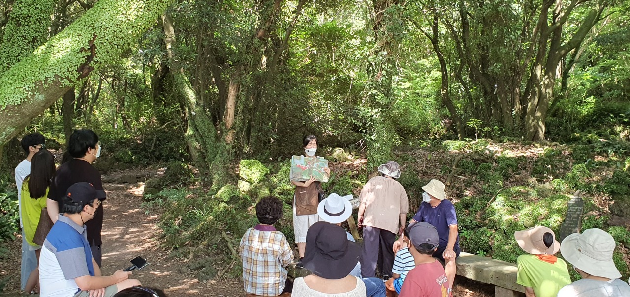 Forest reader Lee Ji-yeong explains the ecosystem of Gotjawal to visitors at Hwansang Forest Gotjawal Park on July 29. (Kim Hae-yeon/The Korea Herald)