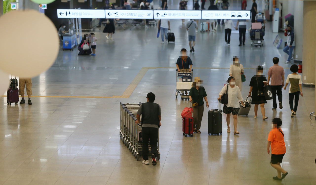 This photo taken on Wednesday, shows people at the Jeju International Airport after the toughest Level 4 social distancing rules take into effect on the southern resort island of Jeju to stem a spike in COVID-19 cases. (Yonhap)