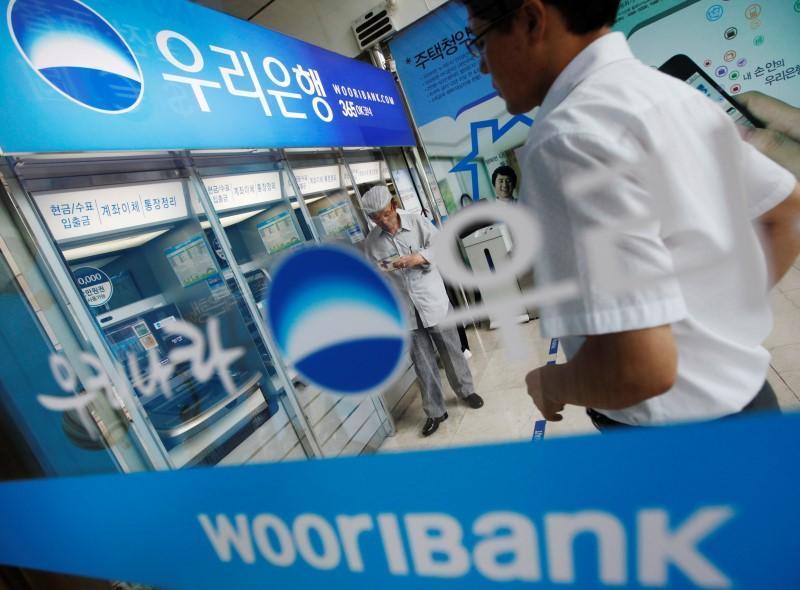 Two men stand by a Woori Bank ATM. (Yonhap)