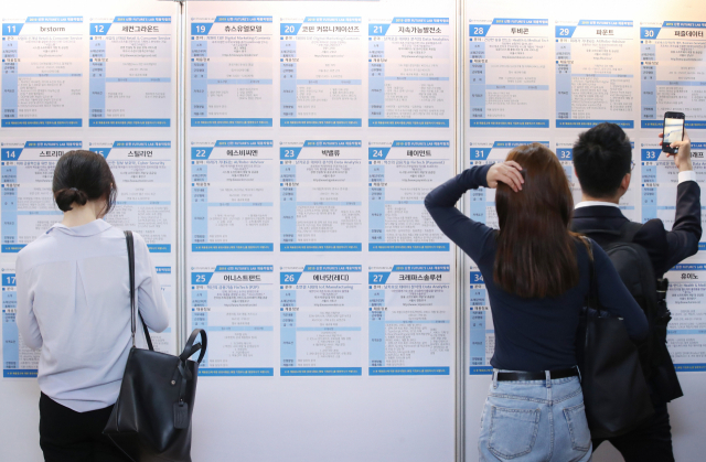 People look at a bulletin board at a startup job fair held in Seoul in 2019. (Yonhap)