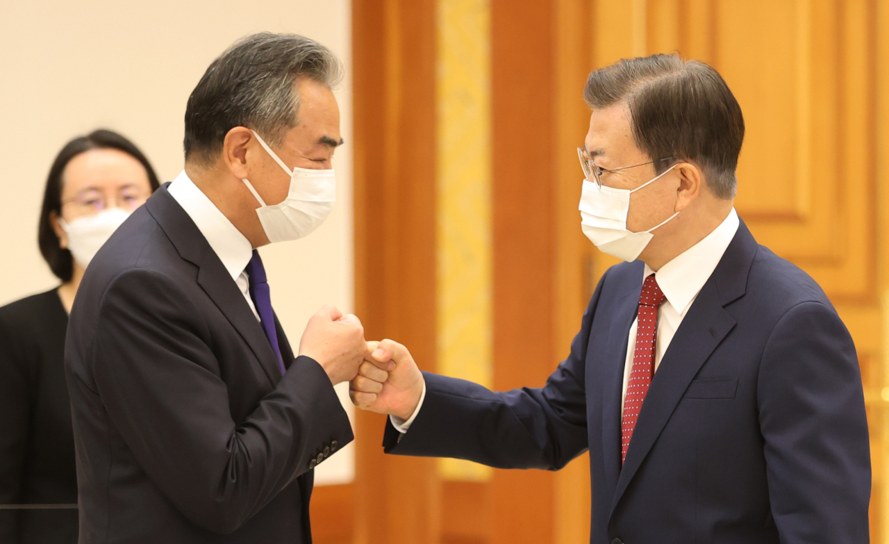 President Moon Jae-in greets Chinese Foreign Minister Wang Yi at Cheong Wa Dae in Seoul on Wednesday. (Yonhap)