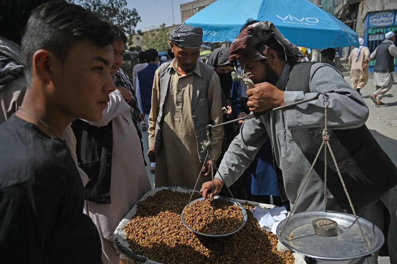 Members of the Hazara community buy dry mulberry at a market on the outskirts of Kabul on Sept. 10 (AFP-Yonhap)