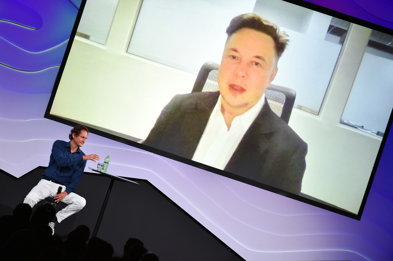 Chairman of Stellantis and Ferrari John Elkann speaks via video conference with Tesla's founder Elon Musk during the 