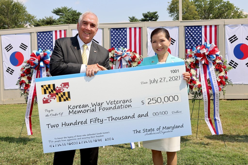 Yumi Hogan (R), the Korean-American wife of Maryland Gov. Larry Hogan, poses with John Tilelli, head of the Korean War Veterans Memorial Foundation, during a ceremony to donate $250,000 to set up the Wall of Remembrance at the Korean War Veterans Memorial in Washington on July 27, 2021, in this photo provided by the governor’s office. (Yonhap)