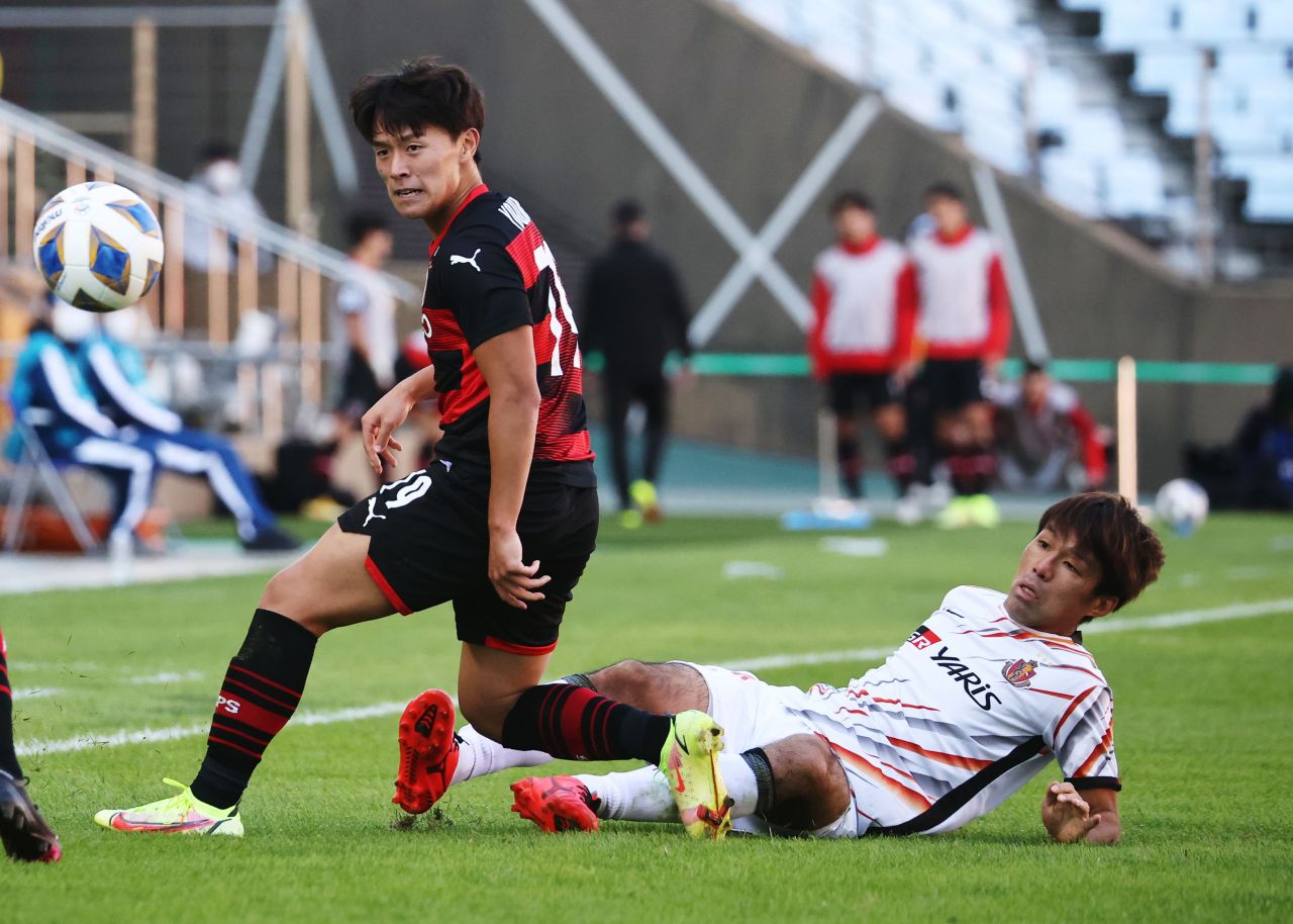 In this photo, Go Young-joon of Pohang Steelers (L) is tackled by Yasuki Kimoto of Nagoya Grampus during the clubs' quarterfinal match at the Asian Football Confederation Champions League at Jeonju World Cup Stadium in Jeonju, 240 kilometers south of Seoul, on Sunday. (Reuters-Yonhap)