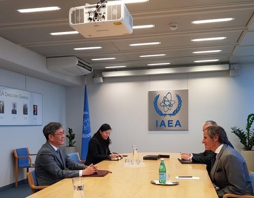 This photo, provided by South Korea's foreign ministry, shows Ham Sang-wook (L), Seoul's deputy foreign minister for multilateral affairs, speaking with Rafael Grossi (R), director general of the International Atomic Energy Agency (IAEA), during a meeting in Vienna last Friday. (South Korean Foreign Ministry)