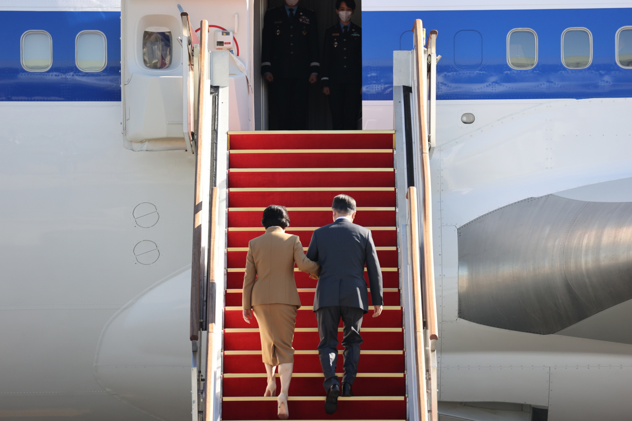 President Moon Jae-in (right) and first lady Kim Jung-sook board a plane at Seoul Airport in Seongnam, south of Seoul, Thursday, for trips to Italy for a meeting with Pope Francis, a Group of 20 summit and Scotland for the COP26, a United Nations climate summit, and a state visit to Hungary. (Yonhap)