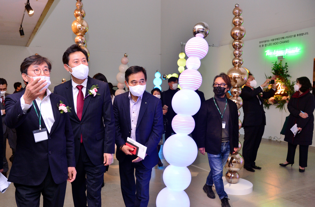 Guests at the opening ceremony of the International Sculpture Festa 2021, including Seoul mayor Oh Se-hoon (center), view sculptures at the Hangaram Arts Center, Tuesday. (Park Hyun-koo/The Korea Herald)
