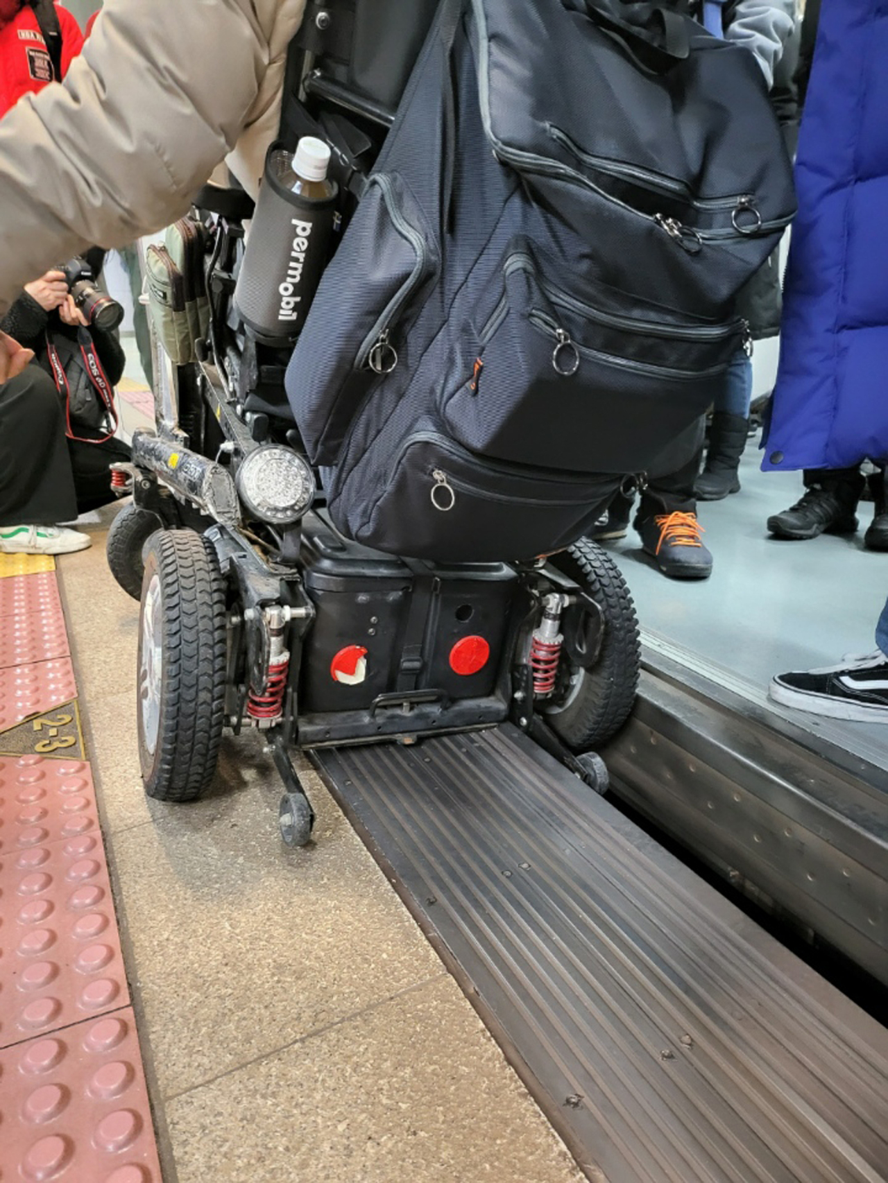 A member of the Solidarity against Disability Discrimination stages a protest by putting his wheel into the gap between a train car and the edge of a station platform at a station on the Seoul Subway Line 5, Monday. (Yonhap)