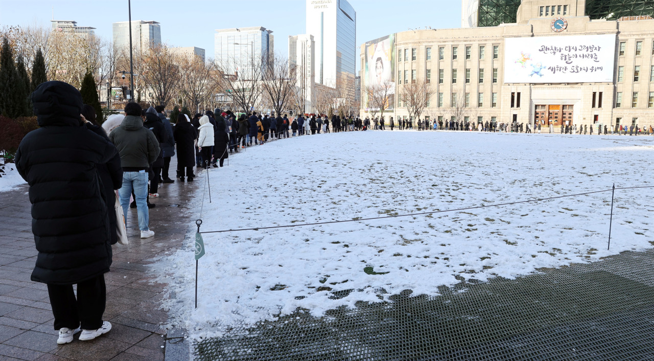 Test seekers form a long queue outside a COVID-19 testing clininc set up near Seoul City Hall on Sunday. (Yonhap)