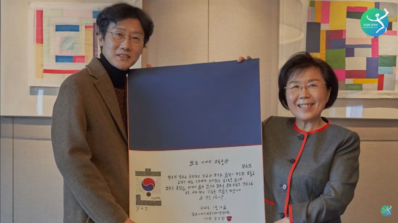 Director Hwang Dong-hyuk (left) and CICI President Choi Jung-wha pose for a photo after Hwang is presented with the Korea Image Stepping Stone Award in December 2021. (Choi JW Rendez-vous YouTube channel)