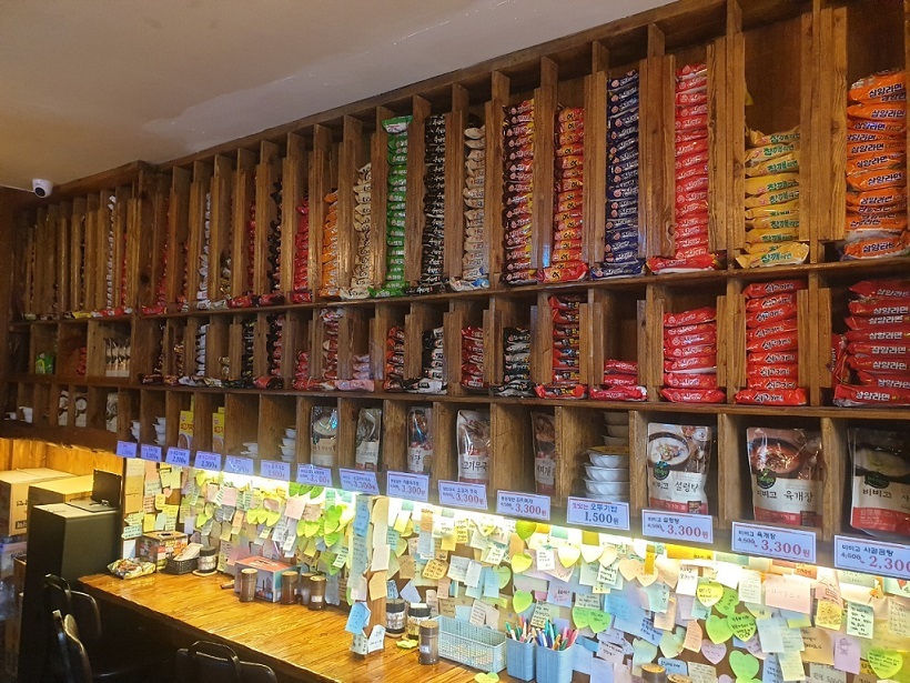 An unstaffed ramen convenience store near Jongno 3-ga Station is open 24 hours. A wall shelf is stacked with packaged instant noodle products of different brands. (Choi Jae-hee / The Korea Herald)